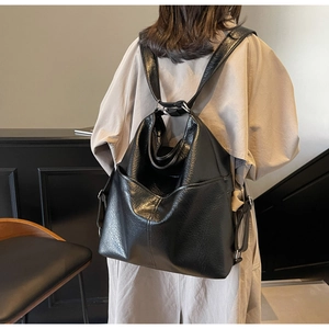 Sac à dos polyvalent en cuir PU noir porté par un mannequin avec un trench-coat beige