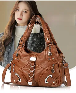 Brown vintage textured leather tote bag featuring braided strap and floral pendant detail