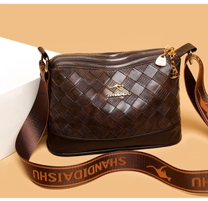 Dettaglio della texture intrecciata marrone scuro e zip dorata della borsa a tracolla