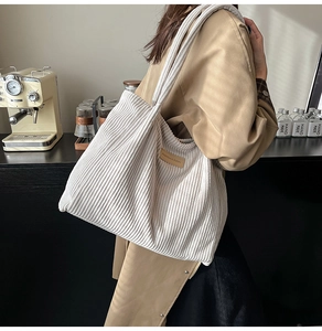 Détail d'un sac cabas en velours côtelé blanc cassé avec étiquette de mode latérale