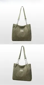 Macro detail of olive green corduroy tote bag with metal chain and leather strap