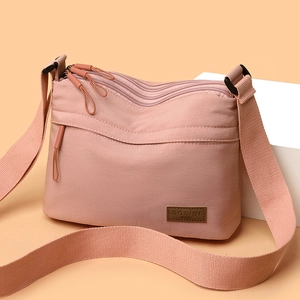 Lightweight mauve nylon crossbody bag with multi-layer zippers and adjustable strap