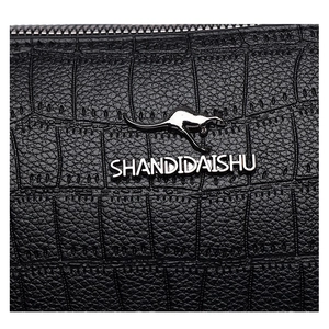 Close-up of black crocodile embossed leather texture with metal kangaroo brand logo