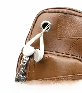 Detailansicht der braunen Ledertasche mit Kopfhöreranschluss und Blumen-Reißverschluss