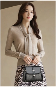 Detail of classic black leather handbag featuring premium gold metal clasp and sturdy top handle