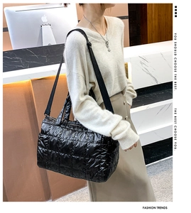 Detail of black quilted space cotton tote bag with glossy finish and adjustable strap