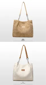 Close-up of corduroy tote bags in yellow and white featuring metal chain leather straps