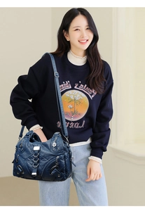 Detail of dark blue vintage leather handbag with multi-pocket design and silver hardware