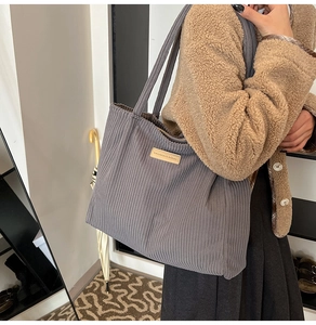 Detail of grey corduroy tote bag featuring a minimalist vintage FASHION & BAG stitched label