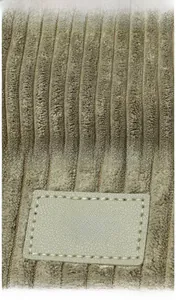 Detailed view of olive green corduroy fabric with embossed brand patch and stitching