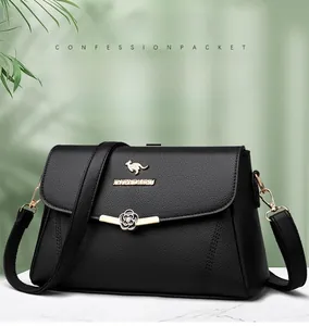 Detail der schwarzen Handtasche aus Leder mit goldenem Känguru-Logo und Blumenverschluss