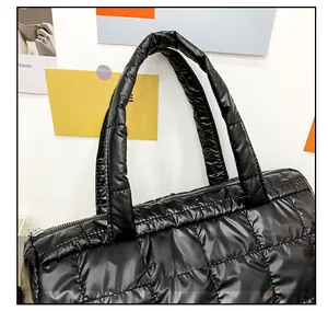 Close-up of black quilted nylon tote with glossy finish and padded handles detail
