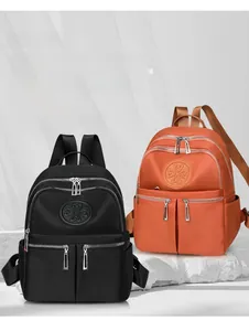 Detailansicht der orangen und schwarzen Nylon-Rucksäcke mit Taschen und Kleeblatt-Logo