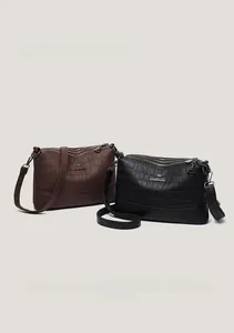 Detailed view of the triple zipper compartments and crocodile embossed leather texture