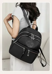 Detail eines schwarzen Nylon-Rucksacks mit Kleeblatt-Logo und silbernen Metallreißverschlüssen