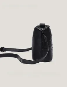 Detail view of black lychee grain leather handbag with fine stitching and metal D-ring