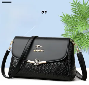 Détail du sac bandoulière noir tressé avec logo kangourou doré et fermoir fleur en métal