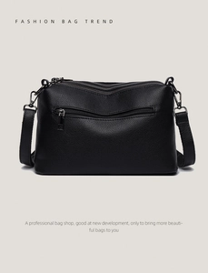 Detail of black lychee texture leather shoulder bag with multi-zippered compartments