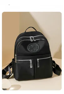 Detail eines wasserfesten schwarzen Nylon-Rucksacks mit silbernen Reißverschlüssen und Fächern