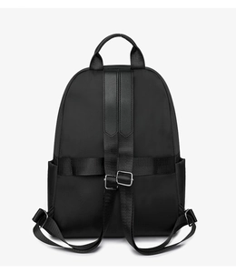 Detail of black nylon backpack back with luggage strap and adjustable silver buckles