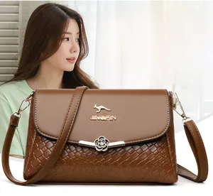 Détails de la texture en cuir tressé marron et du fermoir fleur élégant du sac à bandoulière
