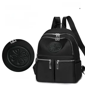 Makrodetail des Nylongewebes und Kleeblatt-Lederaufnähers auf dem schwarzen Rucksack