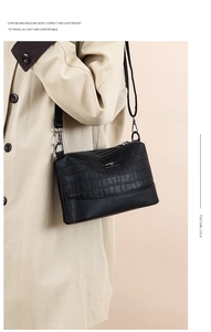 Detail showing high-quality black leather textures and kangaroo logo on the shoulder bag