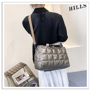 Detail of silver quilted space cotton crossbody bag with wide shoulder strap worn by model