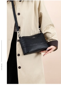 Close-up of black crocodile pattern soft leather crossbody bag with adjustable strap