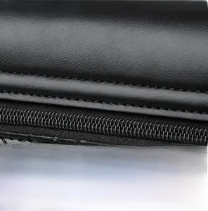 Détail d'un sac bandoulière en cuir noir montrant les coutures précises et l'attache