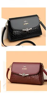 Détail du sac bandoulière en cuir tressé avec logo kangourou et fermoir floral