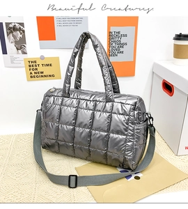 Detail view of metallic silver quilted tote bag with square padding and metal hardware