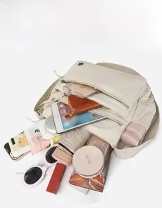 Internal view of a beige nylon crossbody bag showing large capacity and multi-pocket storage