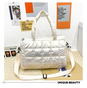 Detail of off-white quilted puffer tote bag with glossy finish and adjustable strap