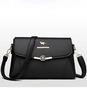 Detailansicht der schwarzen Tasche mit Gold-Logo, Blumenverschluss und Ledertextur