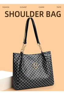 Detail of printed shoulder bag with gold M logo and chain-linked leather handles