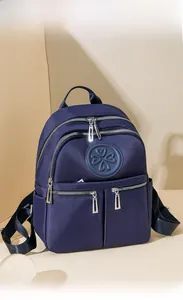 Detailansicht des navy Nylon-Rucksacks mit Vordertaschen und Kleeblatt-Logo-Aufnäher