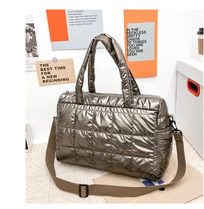 Detail of metallic quilted tote bag with brown adjustable strap and glossy finish