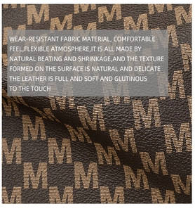 Macro detail of dark brown tote bag material with repeating M-pattern monogram texture