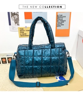 Detail of dark teal quilted puffer tote bag with glossy finish and adjustable strap