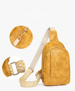 Détail du sac de poitrine jaune avec rivets, cuir grainé et bandoulière ethnique