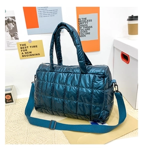 Detail of teal glossy quilted space cotton tote bag with a wide adjustable shoulder strap