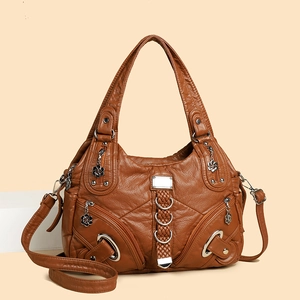 Brown vintage washed leather handbag with woven details and silver floral pendants
