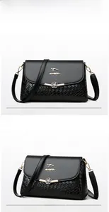 Vue détaillée du sac bandoulière noir tressé avec logo kangourou doré et fermoir fleur en métal