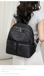 Rückansicht eines schwarzen Nylon-Rucksacks am Modell mit breiten Gurten und Logo
