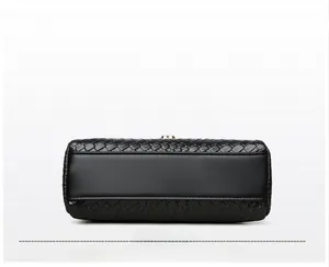 Détail de la texture tressée et de la base en cuir lisse de ce sac à bandoulière noir