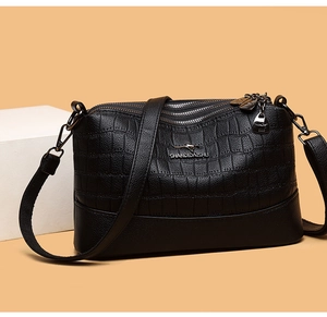 Detail of black faux crocodile leather crossbody bag with triple zipper and metal logo
