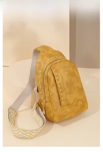 Détail du sac jaune à rivets avec bandoulière à motifs et texture en cuir premium