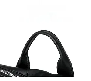 Detail of comfortable rounded leather handle and silver metal zipper on black backpack