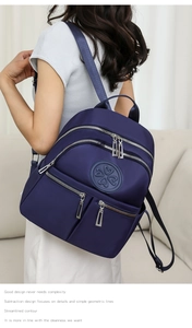 Seitenansicht des dunkelblauen Nylon-Rucksacks mit vielen Taschen, getragen von einem Modell
